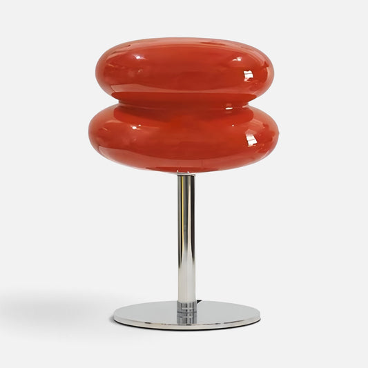 Elvora red stacked glass disc table lamp with a chrome base providing ambient lighting for a modern home interior.